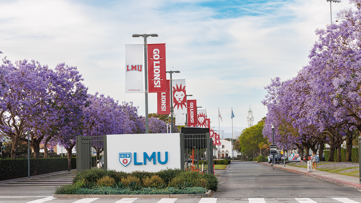 LMU campus entry with sign and banners by trees